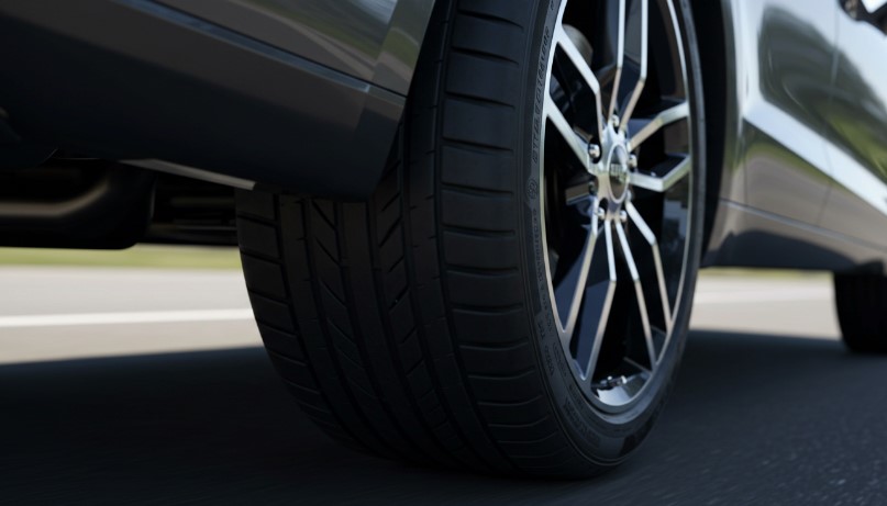 Close-up of a car tire and alloy wheel on the road